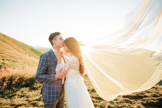 幸せな結婚式のカップルは山を歩いています