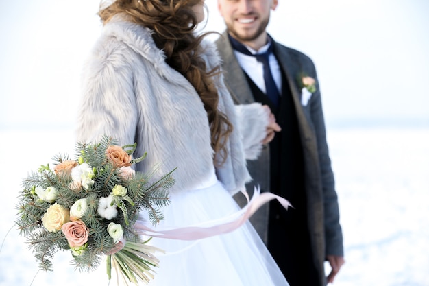 Happy wedding couple outdoors on winter day, closeup