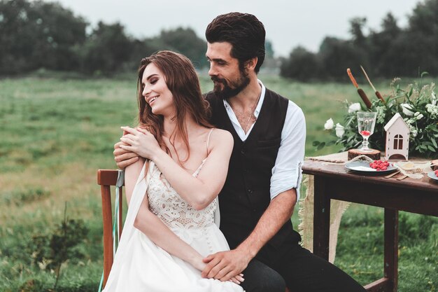 Photo happy wedding couple sitting on chair at farm