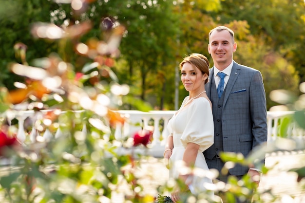 Happy wedding photo of the bride and groom looking at the camera