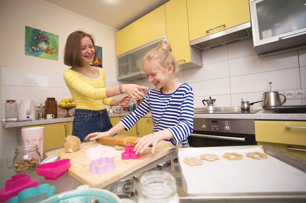 幸せな週末-姉妹の女の子がキッチンでリンツァークッキーを調理します