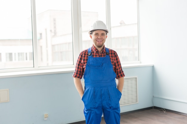 Happy white male builder in front of window,