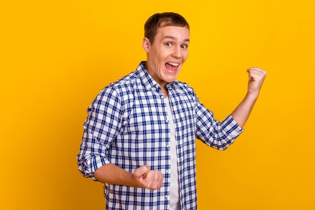 Happy winner Handsome man gesturing fist up celebrate sales isolated bright shine color background