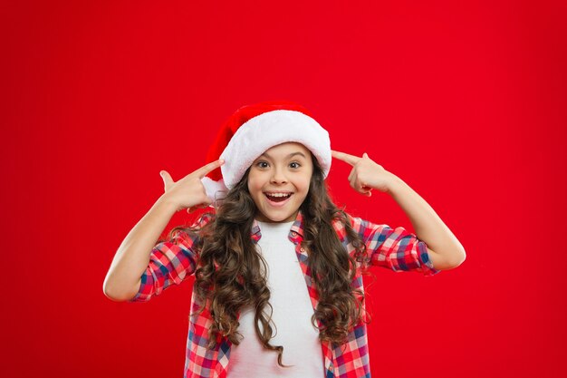 Happy winter holidays. Small girl. Present for Xmas. Childhood. Little girl child in santa hat. Christmas shopping. New year party. Santa claus kid. Merry Christmas and Happy New Year.