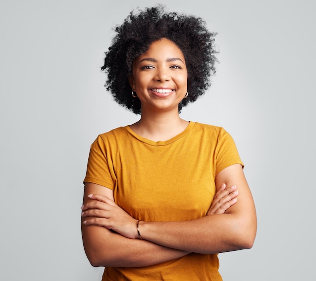 Happy woman and arms crossed for portrait in studio white background and backdrop Young female model smile and natural curly afro hair with positive personality gen z and girl of South Africa