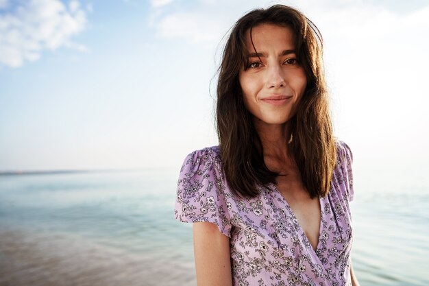 Donna felice sulla spiaggia che cammina in riva al mare