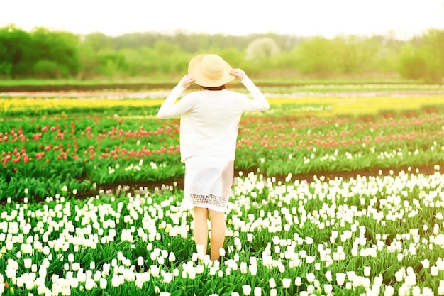 Happy woman on blooming field of tulips