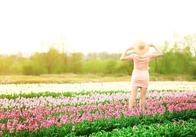 Happy woman on blooming field of tulips