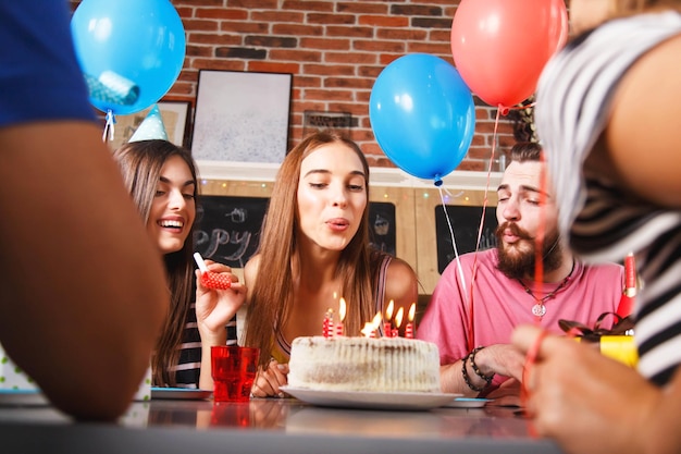 Photo happy woman blowing candles on cake