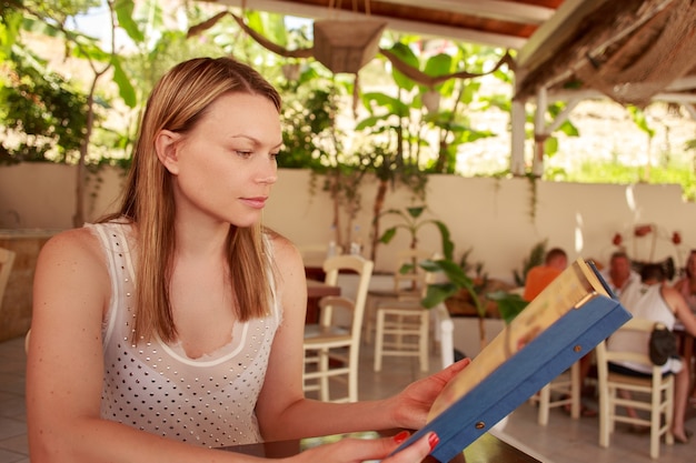 Happy woman in cafe with menu