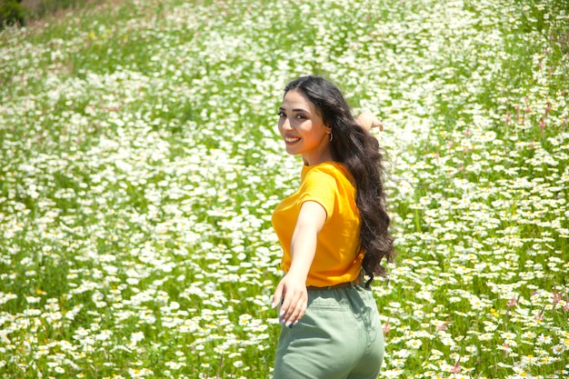 Happy woman in the chamomile field