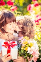 Photo happy woman and child with beautiful spring flowers against green background family holiday concept mothers day