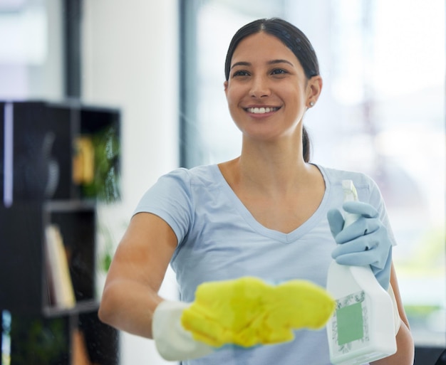 Happy woman and cleaning glass with bottle gloves and detergent for housekeeping in home or office Cleaner service and female domestic cleaner with product for bacteria dust or germ prevention