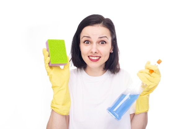 happy woman in cleaning gloves holding dishwashing sponge and household chemicals