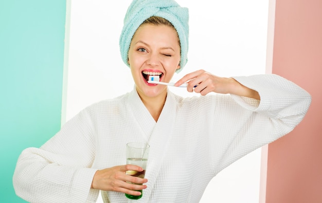 Happy woman cleaning teeth with toothbrush. Dental hygiene. Oral care. Winking girl brushing teeth.