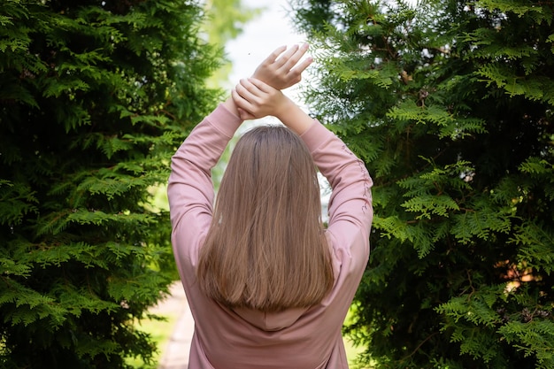 Happy woman in the coniferous trees at sunset freedom concept High quality photo