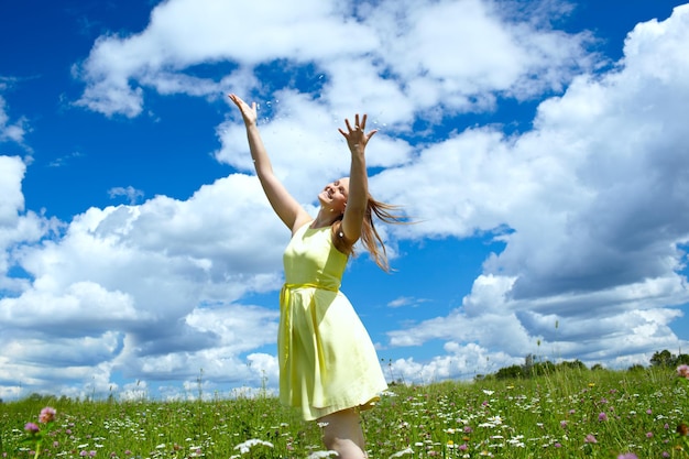 写真 空に向かってフィールドで踊る幸せな女性