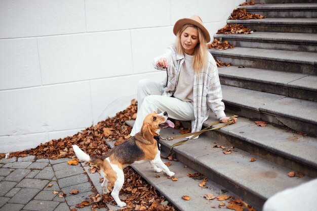 幸せな女性と犬のビーグル犬が屋外で一緒に遊んでいます。