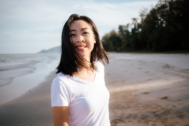 Happy woman enjoy the sunset light on the beach.