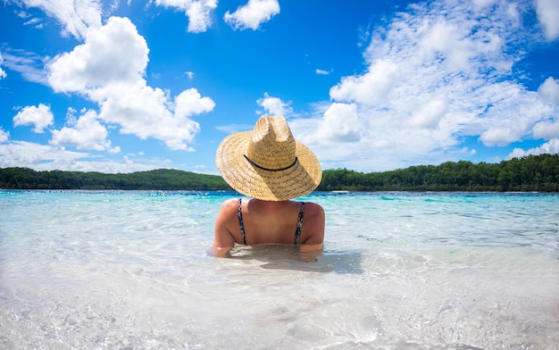 Happy woman enjoying beach relaxing joyful in summer by tropical blue water.