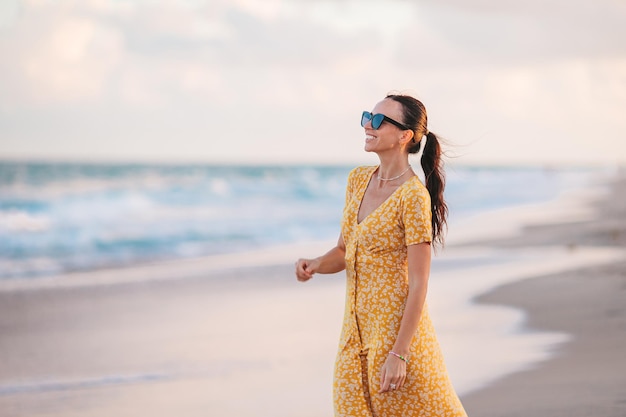 Donna felice che gode del bel tramonto sulla spiaggia