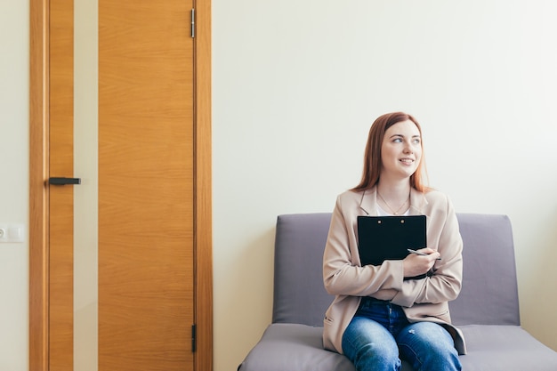 Happy woman expects positive new and good interview results in the waiting room