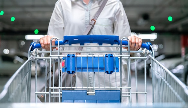 Счастливая женщина женская тележка для покупок или тележка на автостоянке свежего макета в супермаркете