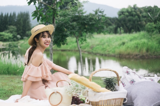 Happy woman go picnic at garden near river