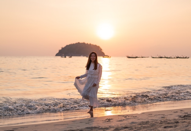 Happy woman going travel on tropical sand beach in summer