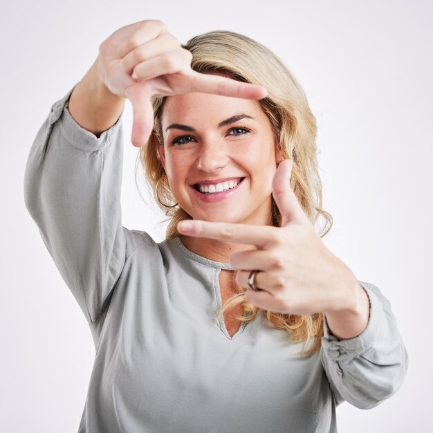 Happy woman hands and frame for portrait selfie photo or profile picture against a white studio background Female border face and smiling in focus for perfect photography social media or capture