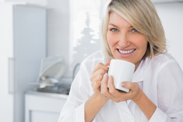 Donna felice che mangia caffè di mattina