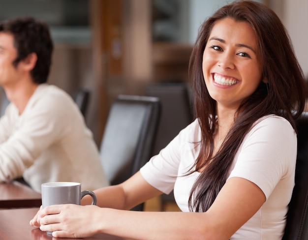 コーヒーを持っている幸せな女性