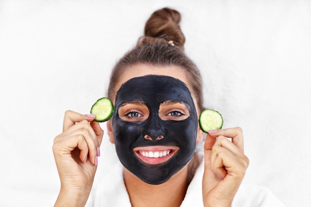 happy woman having facial in spa salon