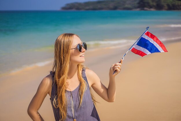 Happy woman having fun at the beach with Thailand flag Beautiful girl enjoying travel to Asia