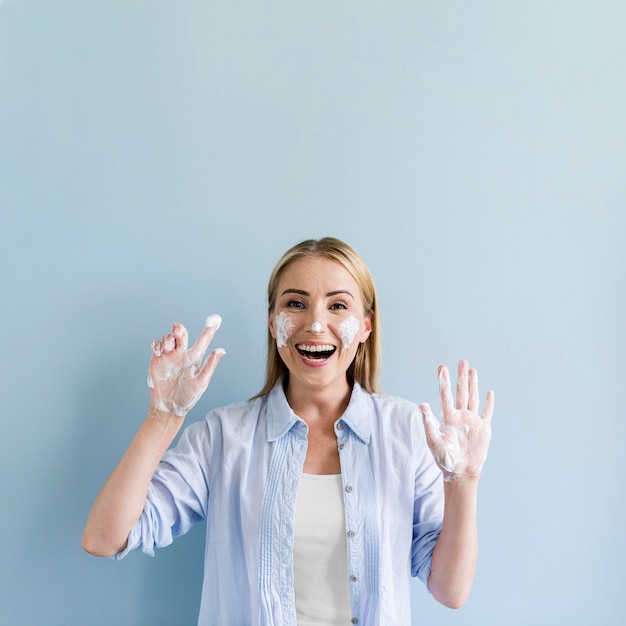 Photo happy woman having fun while washing her hands and face