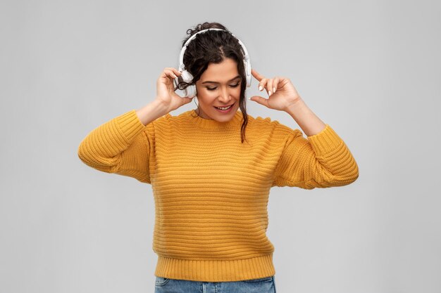 音楽を聴くヘッドフォンをかぶった幸せな女性