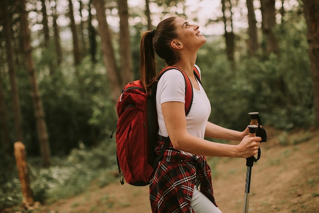 Donna felice che fa un'escursione nella foresta