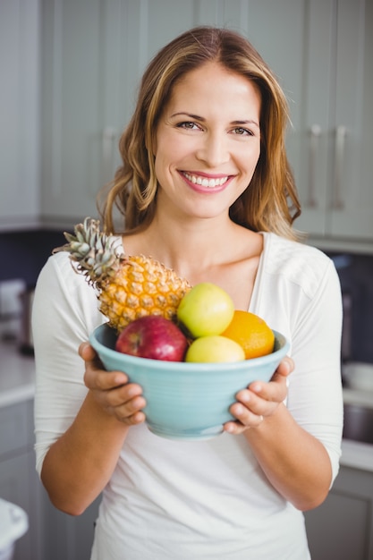 Фото Счастливая женщина, держащая вазу с фруктами