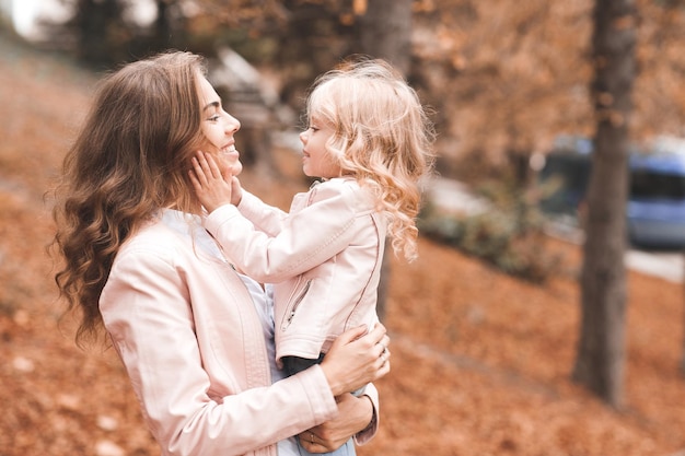 Happy woman holding baby girl outdoors