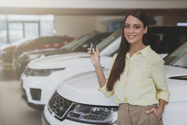 Happy woman holding car keys to her new automobile