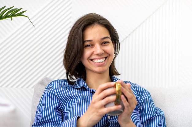 Happy woman holding a cup of coffee female chill with drink with satisfaction and self care