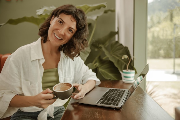 Happy woman holding a cup of coffee