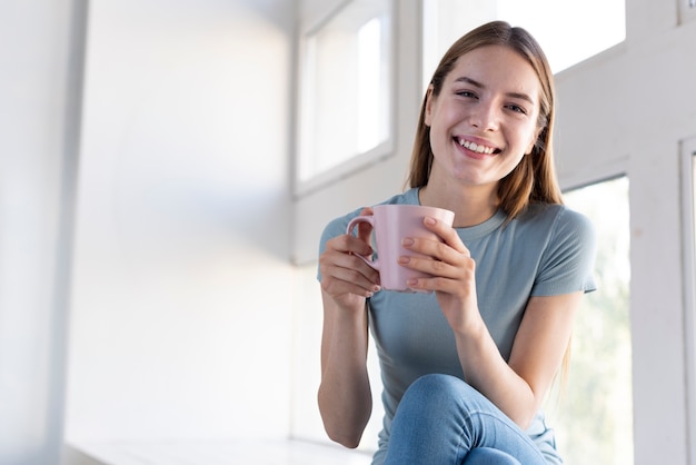 Photo happy woman holding a cup of coffee