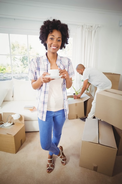 Happy woman holding cup in the living room