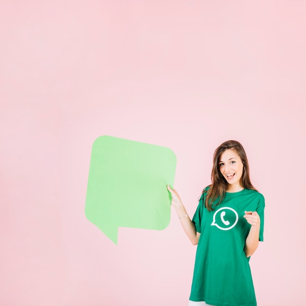 Happy woman holding empty green speech bubble