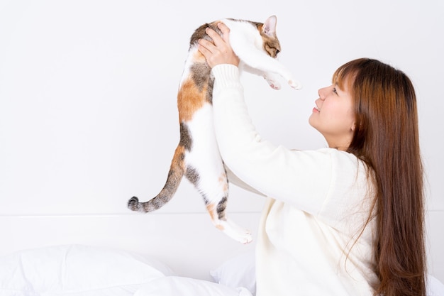 彼女の素敵なふわふわ猫を保持している幸せな女性。