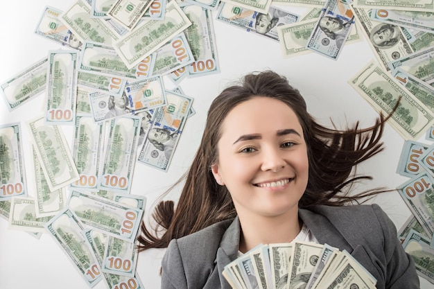 happy woman holding a pile of dollar bills