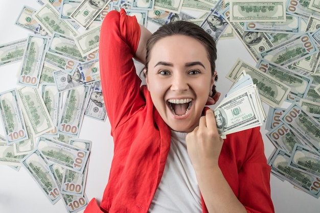happy woman holding a pile of dollar bills