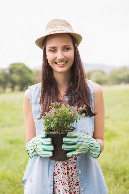 Happy woman holding potted flowers