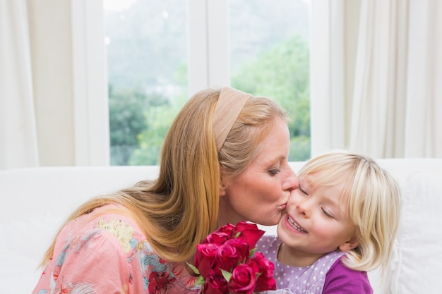 Happy woman holding red roses with daughter